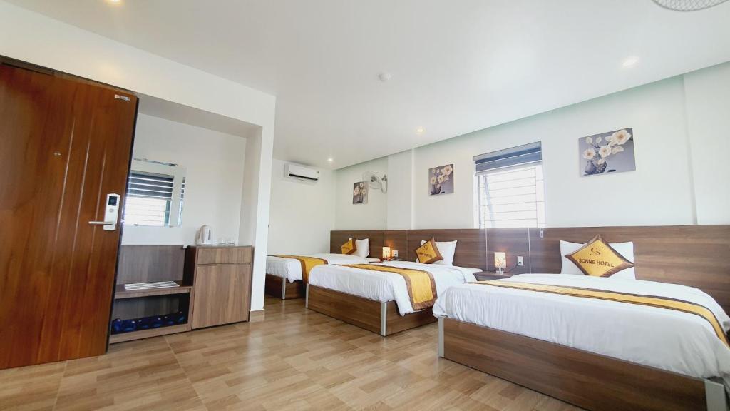 Ðộng HỏiSonne Hotel Quang Binh的酒店客房设有两张床和电视。