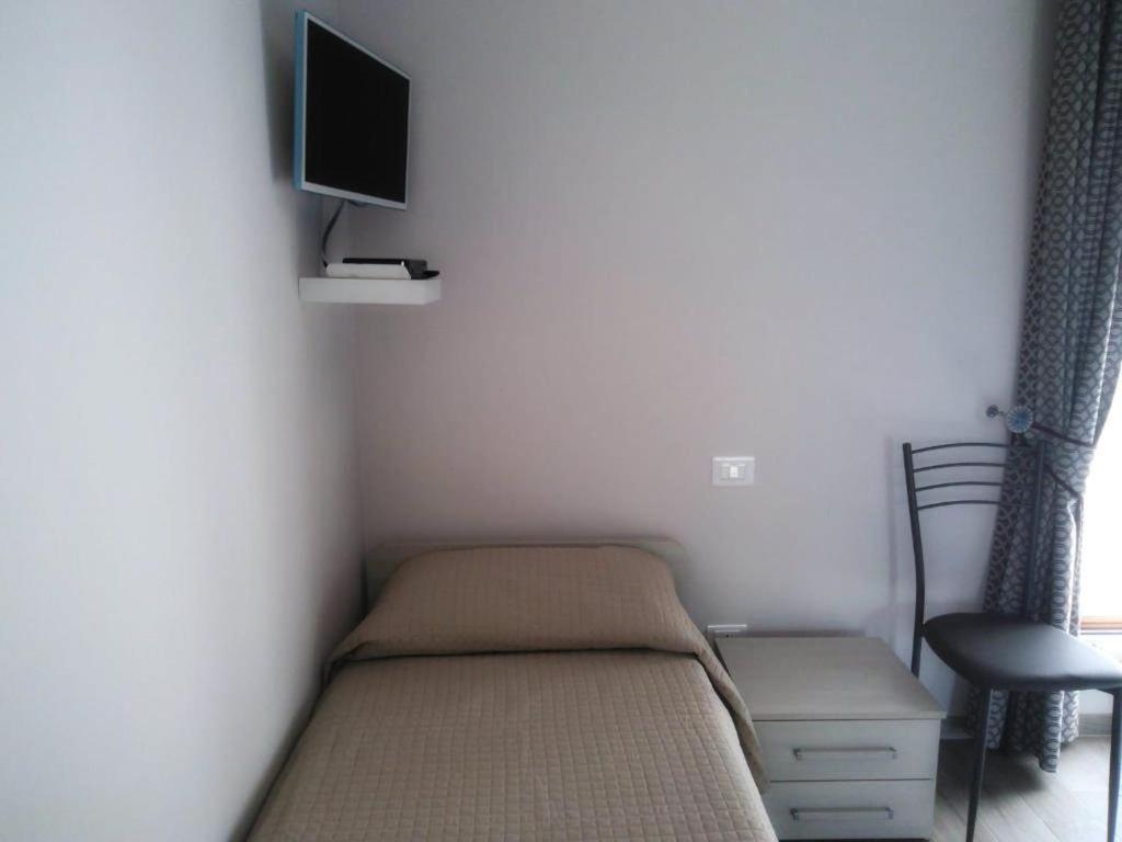 阿尼奥内B&B Tirassegno的一间小卧室,配有一张床和一台墙上的电视