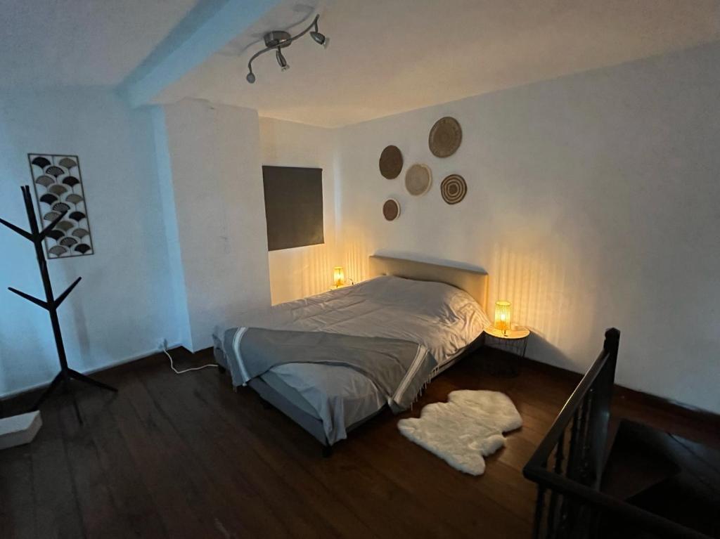 OlneCharmante petite maison à Olne的卧室配有一张床,墙上有两盏灯