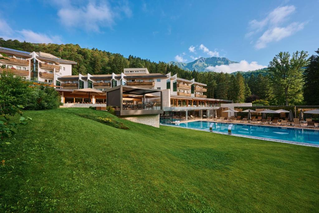 科马诺泰梅Grand Hotel Terme Di Comano的一座带游泳池和草坪的大型建筑