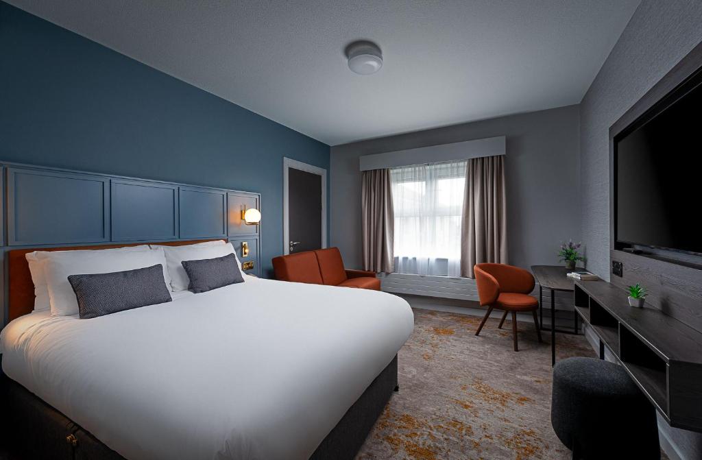 戈尔韦Leonardo Hotel Galway的酒店客房设有一张大床和一台电视。