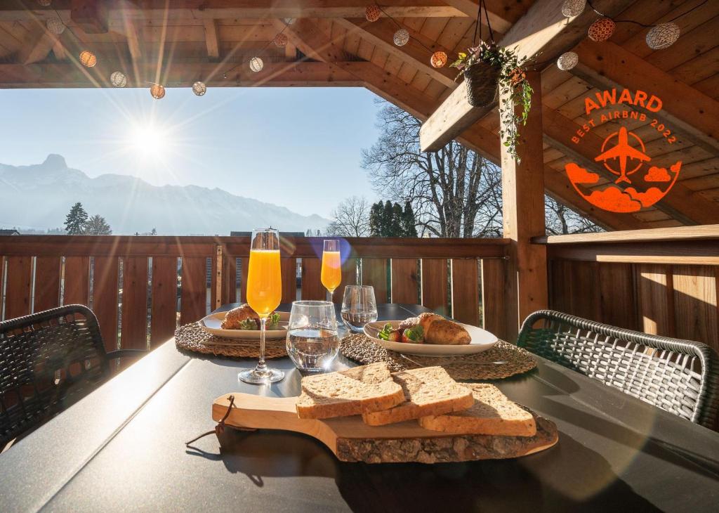图恩Swiss Alps View Apartment - contactless self check-in的甲板上的桌子,上面摆放着面包和酒杯