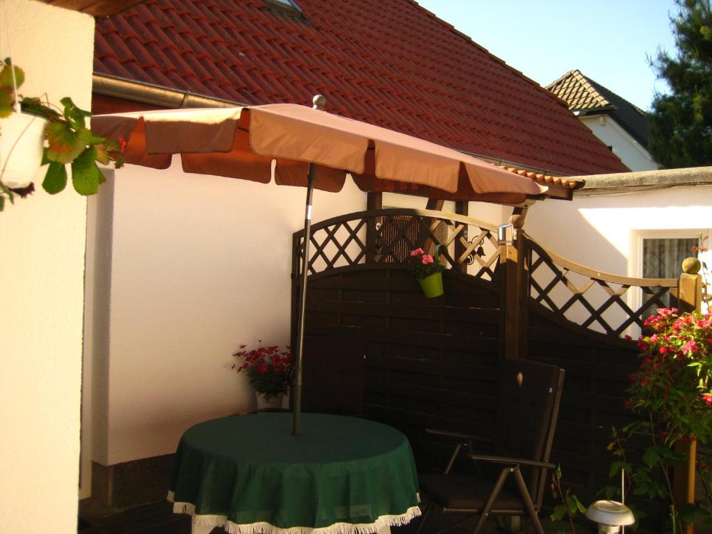 博恩Ferienhaus Abendsonne的一个带桌子和遮阳伞的庭院