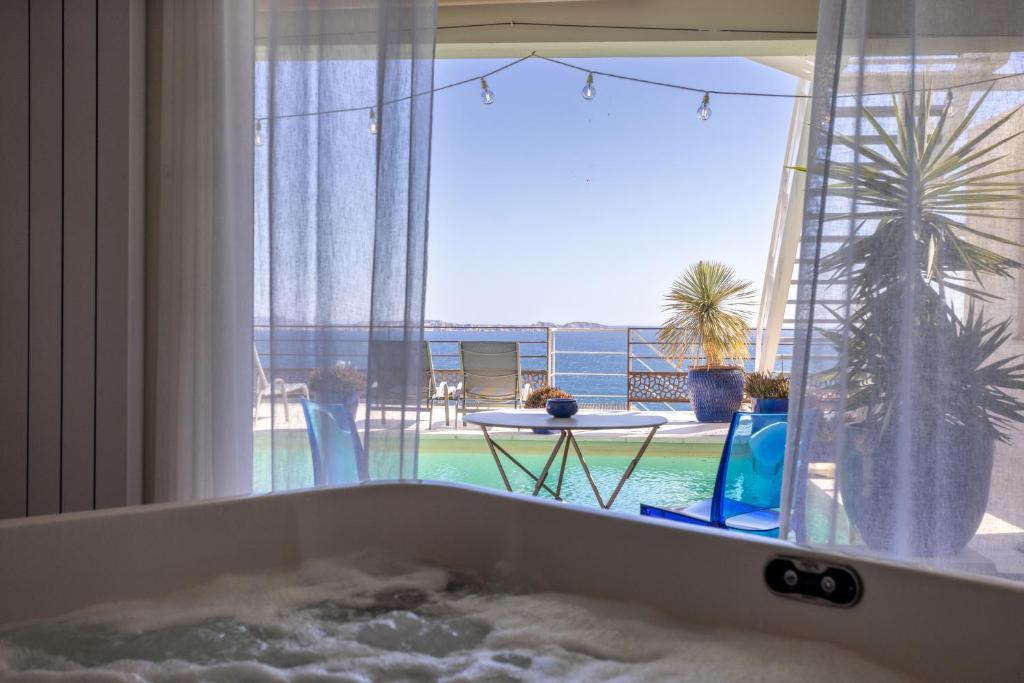 马赛LES SUITES LOVE 1 SPA VUE MER PISCINe的海景浴缸