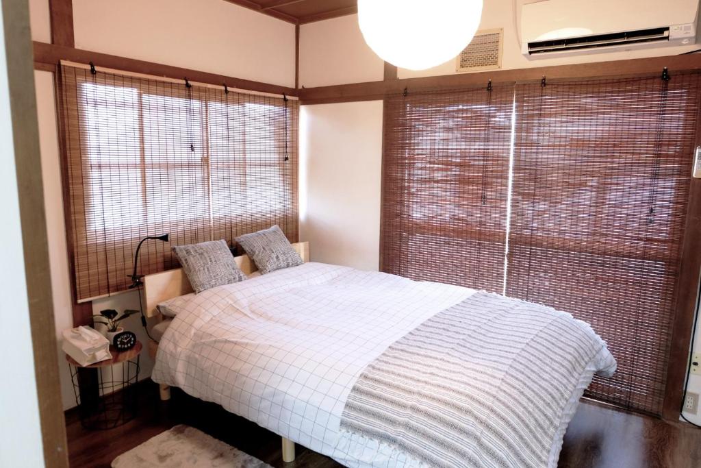武藏野Daiichi Mitsumi Corporation - Vacation STAY 15266的一间卧室设有一张床和一个大窗户