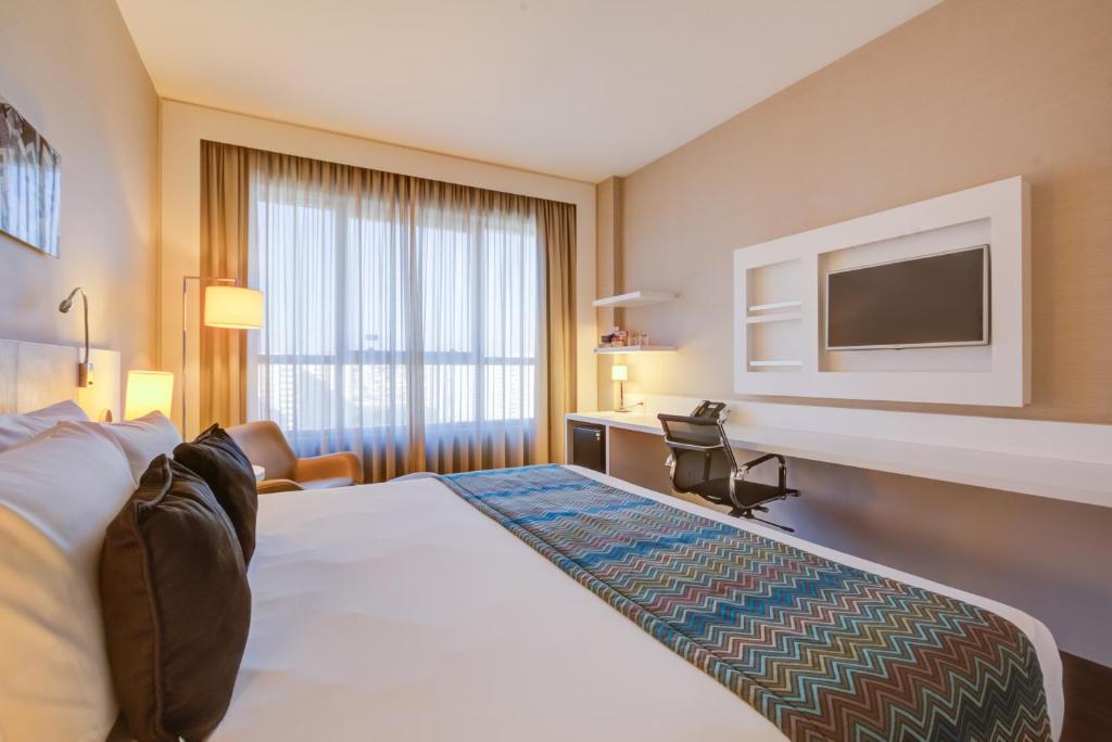 南圣卡埃塔诺圣卡伊塔诺品质酒店的配有一张床和一台平面电视的酒店客房