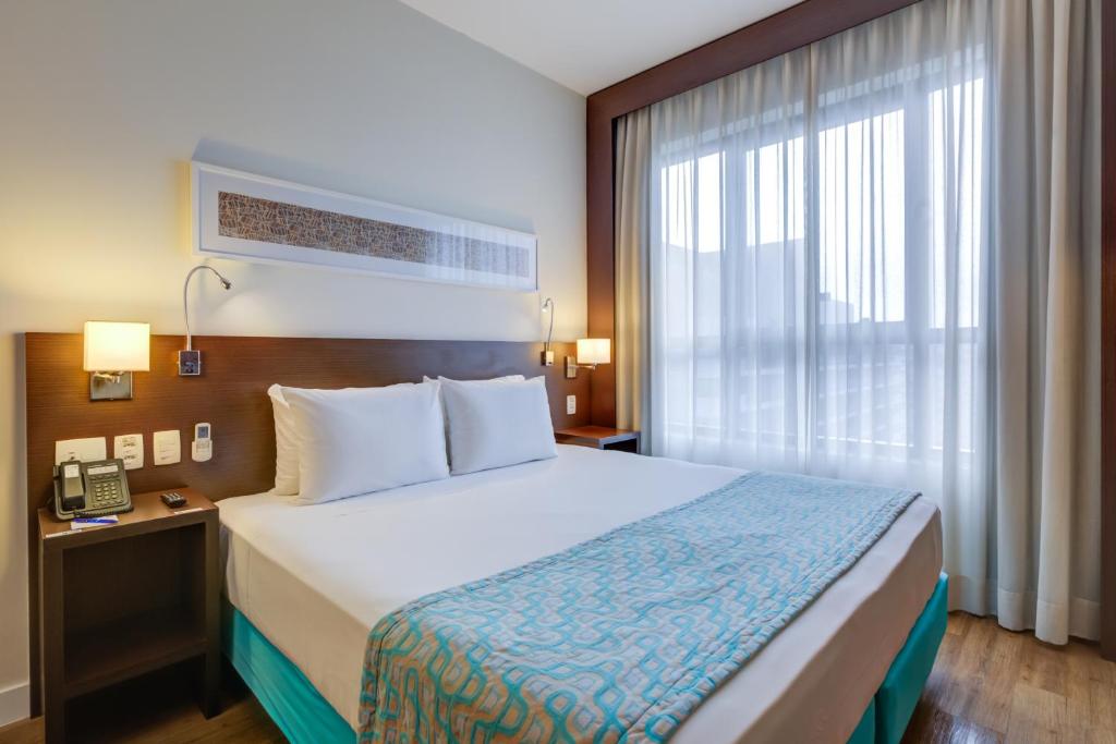 南圣卡埃塔诺Comfort Hotel São Caetano的酒店客房设有床和窗户。