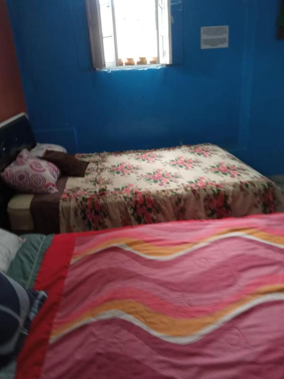 基多HOTEL EL PANECILLO-Tanta的蓝色的客房配有一张带彩色毯子的床