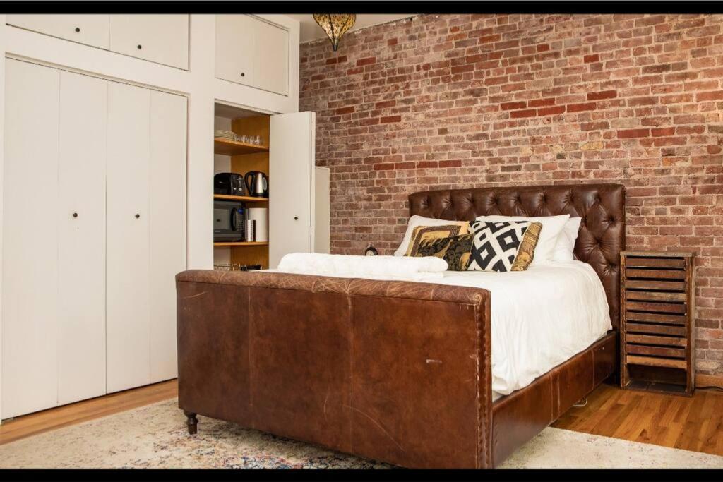 纽约Prime Studio Greenwich Village!的一间卧室设有一张大床和砖墙