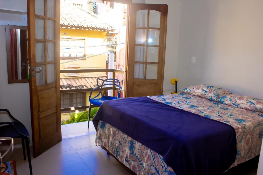 普拉亚多Suíte na vila de Praia do Forte的一间卧室设有一张床和一个美景阳台