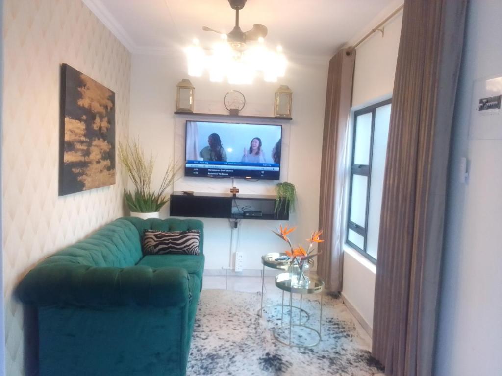 比勒陀利亚Elegant Airbnb的客厅配有绿色沙发和电视