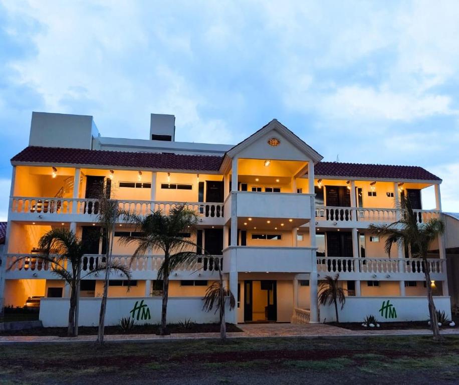 瓦曼特拉Hotel & Cabañas Malinche的一座棕榈树环绕的大建筑