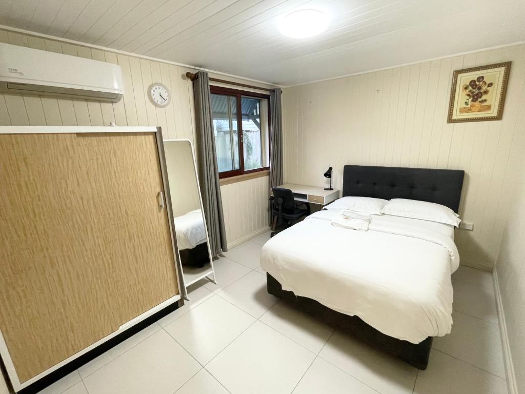 布里斯班197 Shafston Ave Kangaroo Point QLD 4169的卧室配有白色的床和窗户。