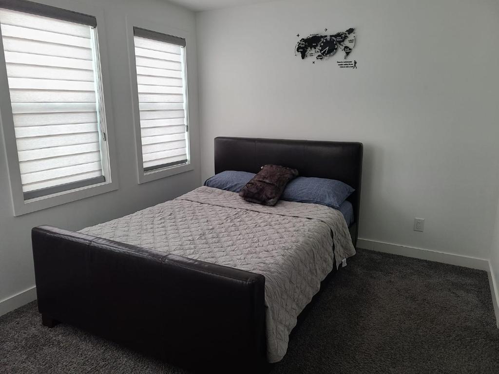 温尼伯Winnipeg Peace Home的一间卧室设有一张床和两个窗户。
