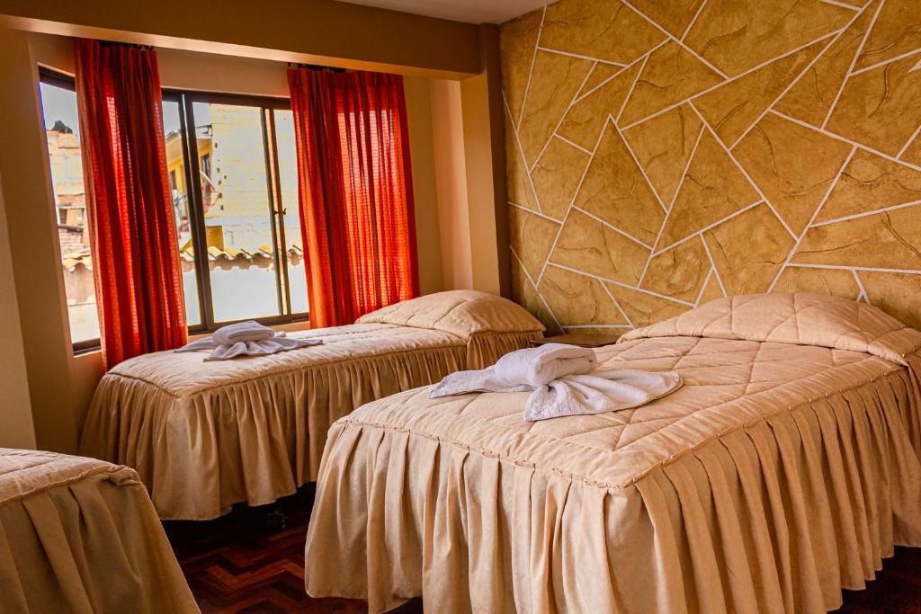 科帕卡巴纳Hostal Sonia的酒店客房设有两张床和石墙。