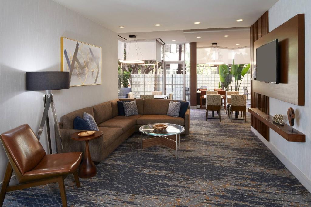 洛杉矶洛杉矶LAX/世纪大道万怡酒店的客厅配有沙发和桌子