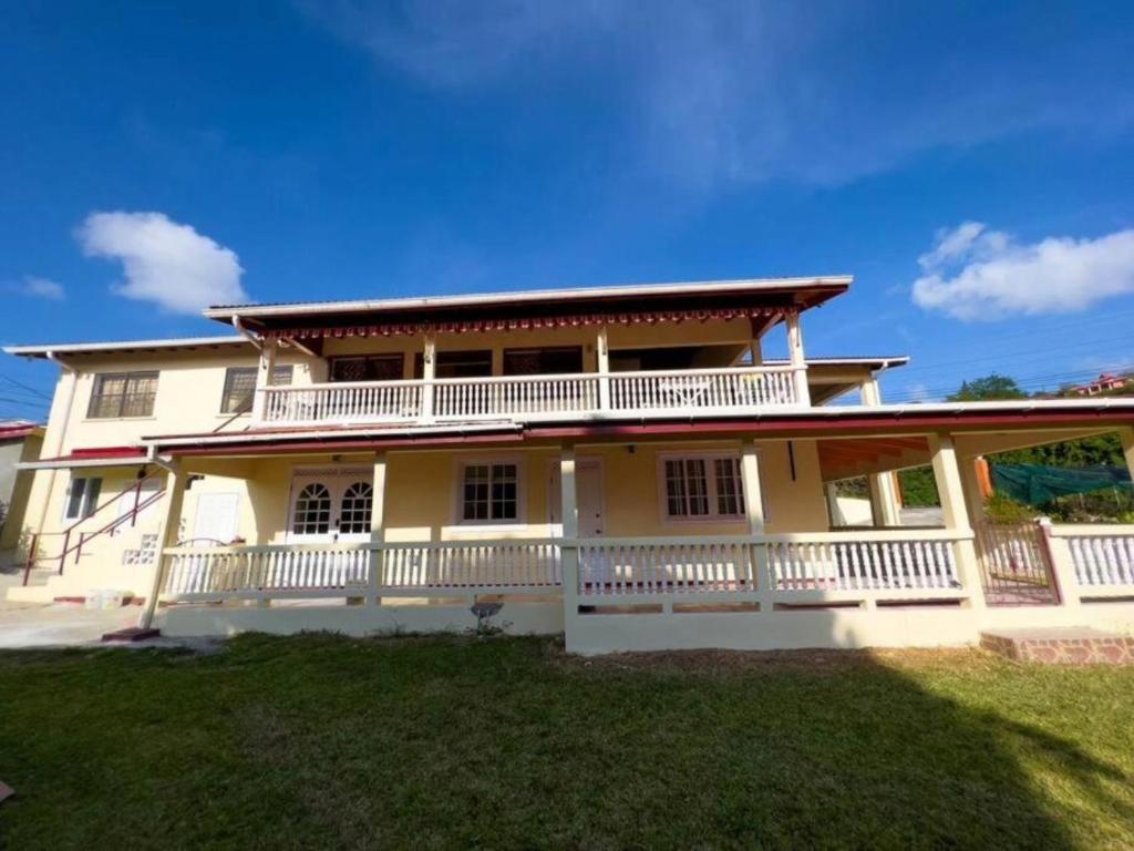 格罗斯岛Chalet Belizomi Tropical Villa #1的大型黄色房屋设有大阳台