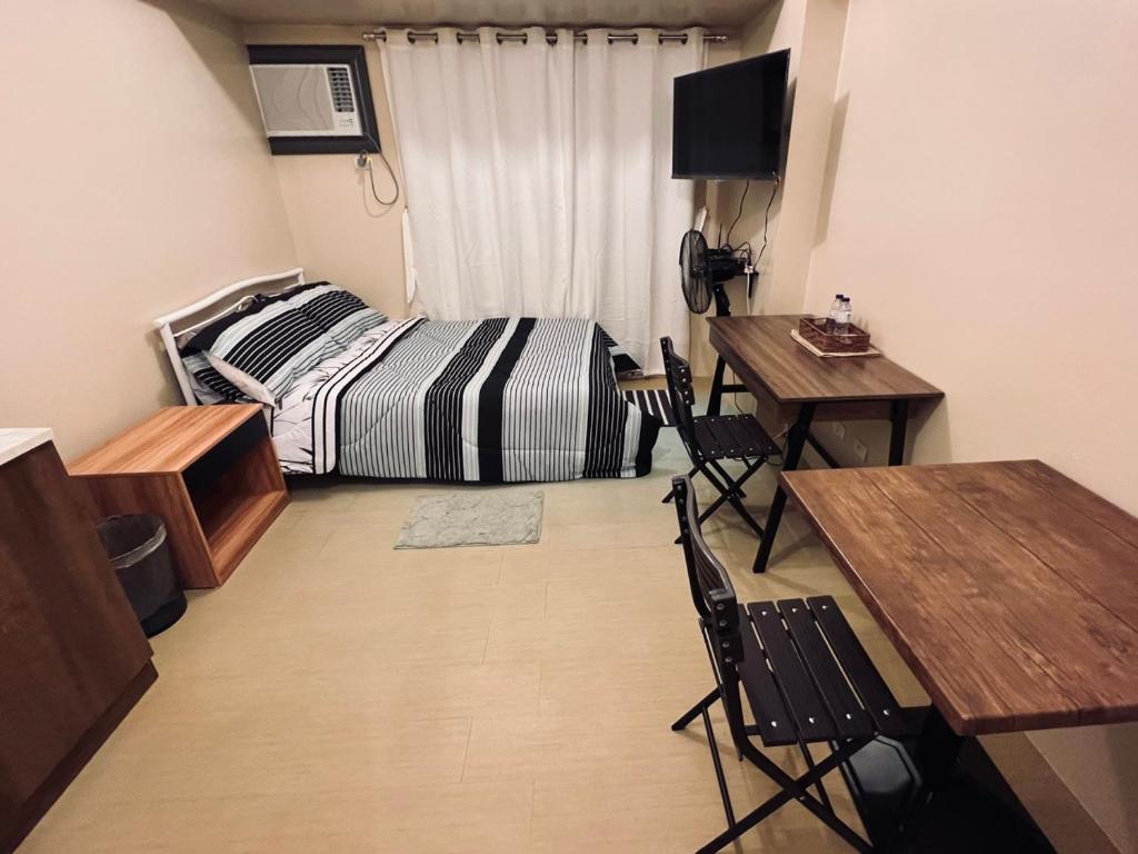 伊洛伊洛C Comfortable Avida Room的卧室配有一张床和一张桌子及椅子