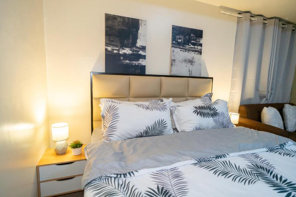 马尼拉A2J Luxury 2BR BGC Suite Near SM Aura, Market2x的一间卧室配有一张铺有白色床单和棕榈叶的床。