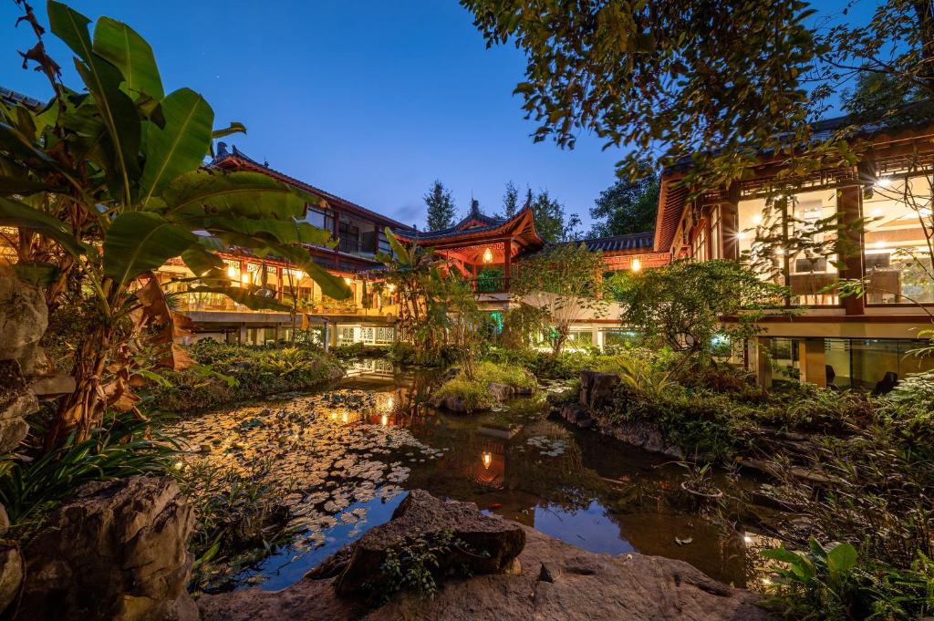 桂林桂林訾洲四景度假酒店的前面有池塘的房子