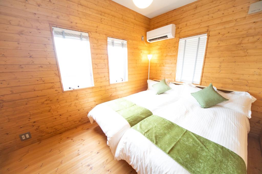 KusumotoAwaji Seaview Resort in Nojima的卧室配有木墙和窗户。