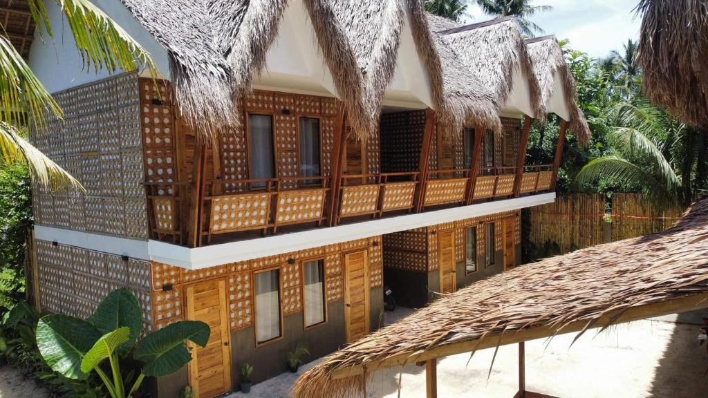 卢纳将军城M-Resort Siargao的一座带木门廊和阳台的建筑
