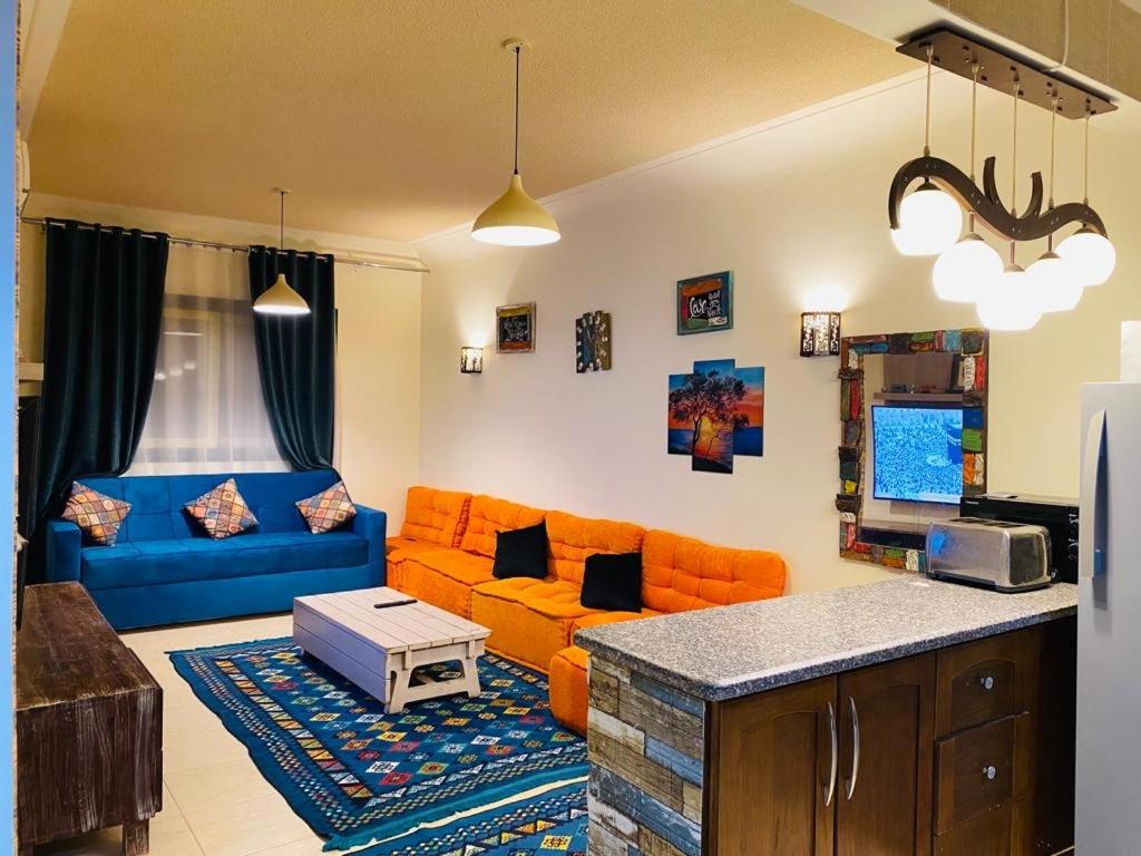 拉斯苏德尔Furnished Chalet Apartment at La Hacienda Ras Sedr的客厅配有橙色家具和蓝色沙发