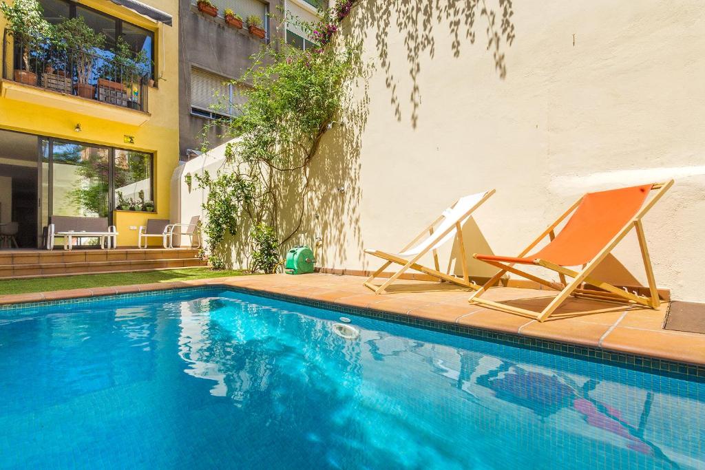巴塞罗那L'alzina Apartment的游泳池旁的两把椅子