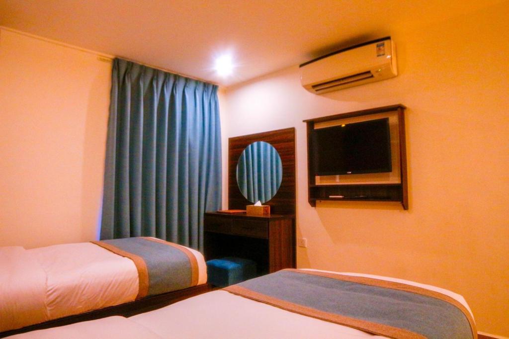 亚喀巴ِAfnan hotel的酒店客房设有两张床和一台平面电视。
