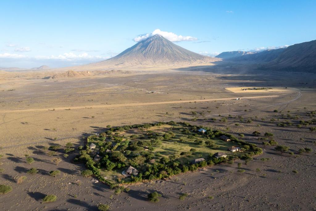 MtowabagaLake Natron Maasai giraffe eco Lodge and camping的沙漠中的岛屿,以山为背景