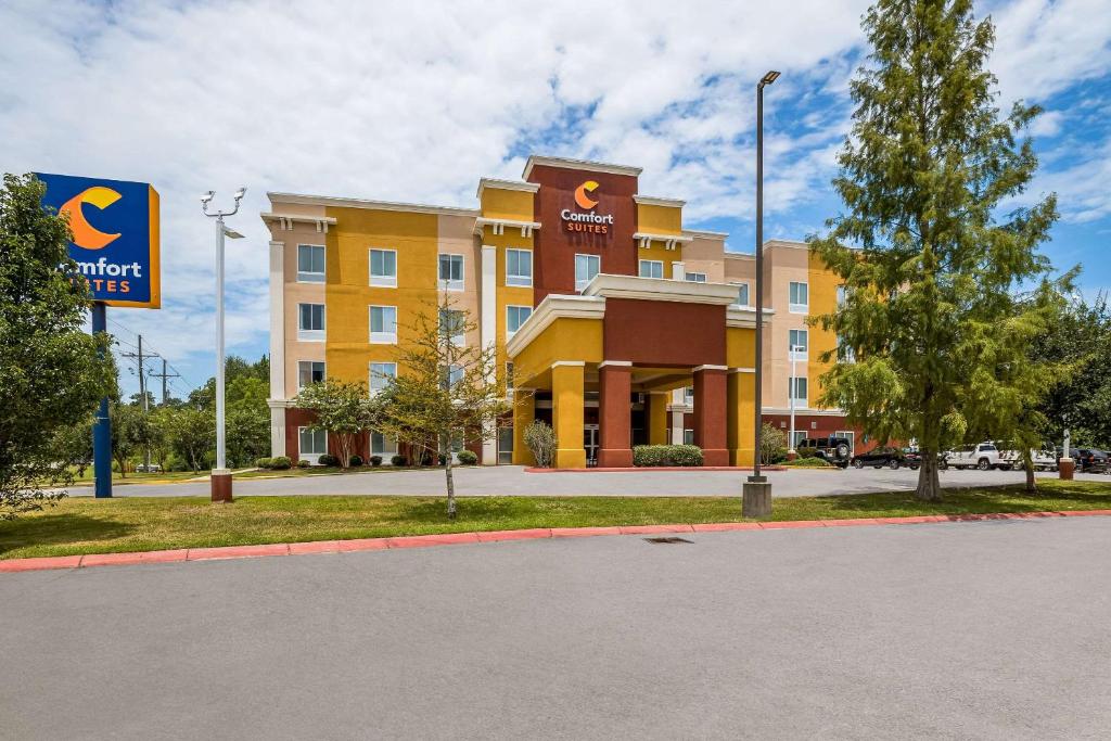 德纳姆斯普林斯德纳姆泉康福特套房酒店的一座黄色的大建筑,前面有标志
