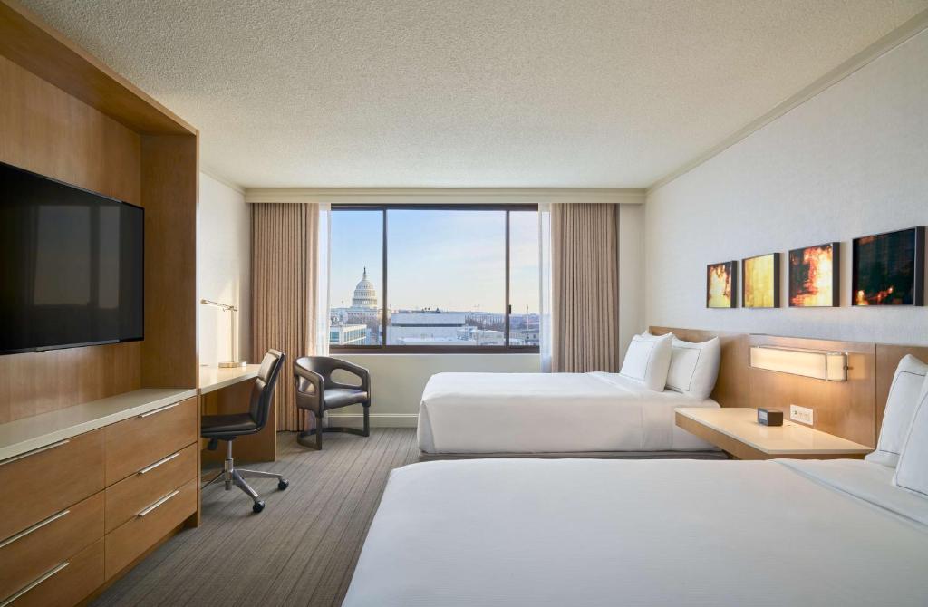 华盛顿Hilton Washington DC Capitol Hill的酒店客房设有两张床和一台平面电视。