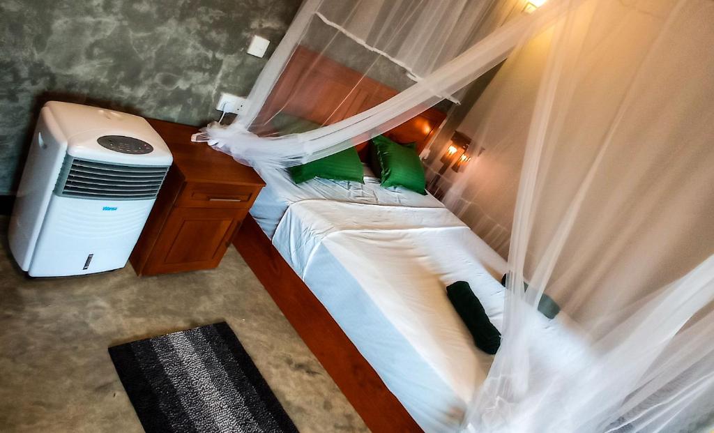 代尼耶耶Rain Forest Star的一间卧室配有两张床、窗帘和书桌