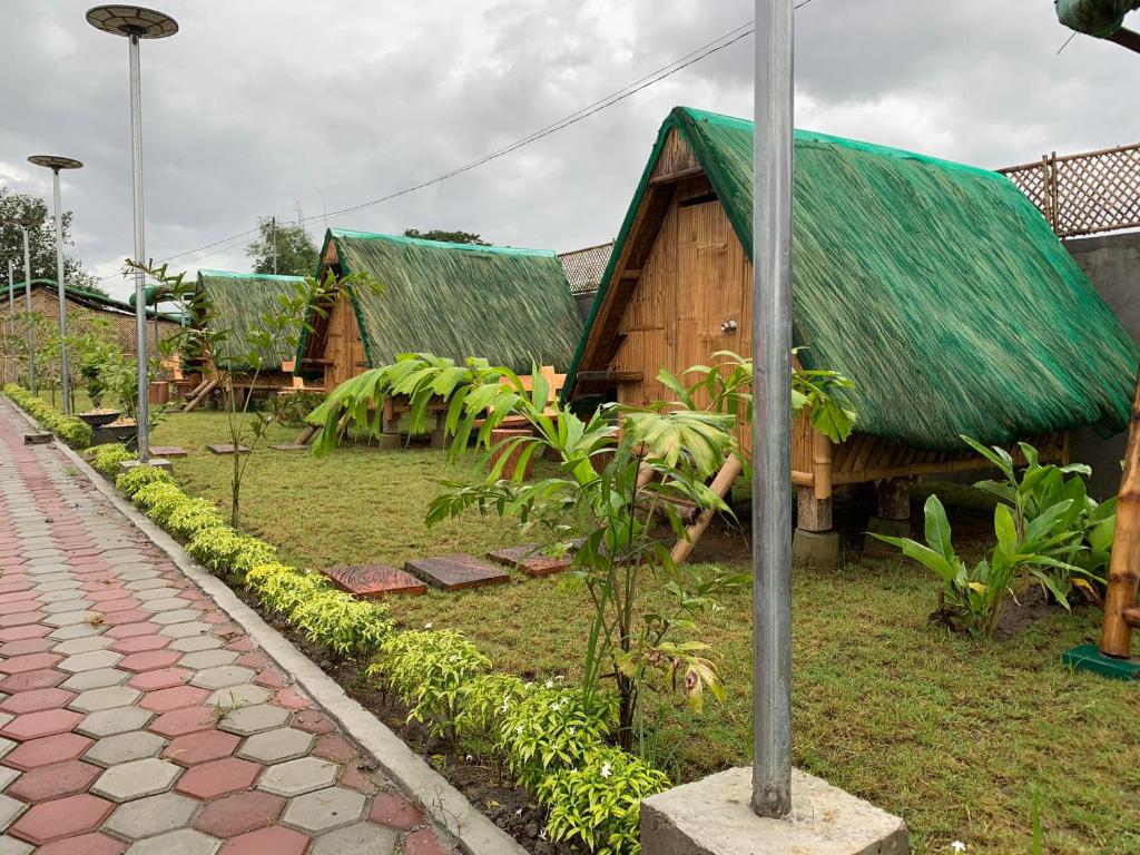 丹辘Unlimited Pax Bale Kubo-inspired Accommodation的绿色屋顶和人行道的房子