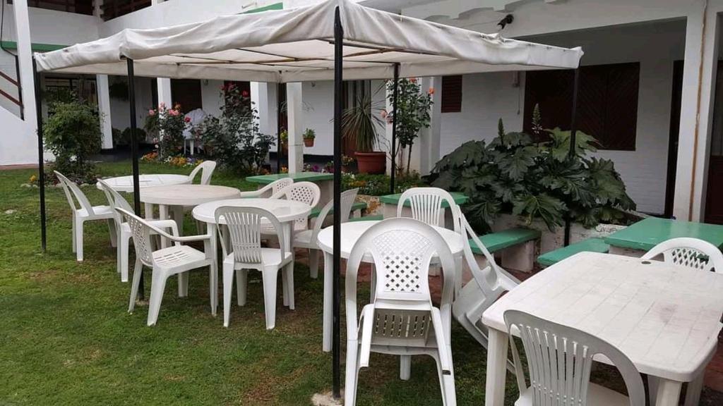 米娜克拉韦罗Hotel 20 de Junio的一组桌子和椅子,放在伞下