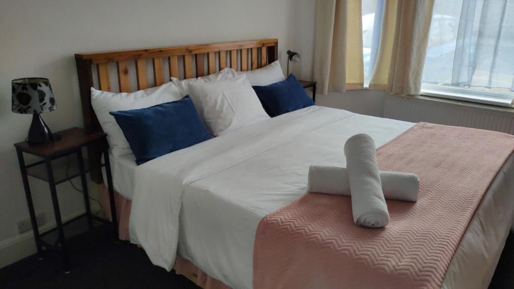 桑当Fair Oak Self-Catering Accomodation的卧室配有带蓝色枕头的大型白色床
