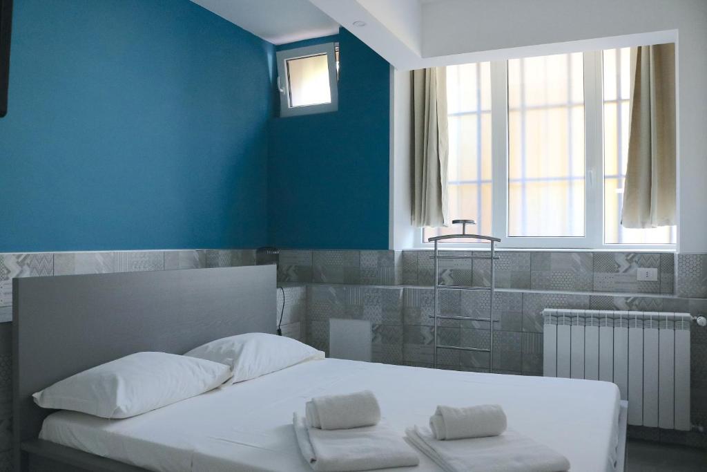 米兰Gambara GuestS House的卧室配有白色的床和蓝色的墙壁