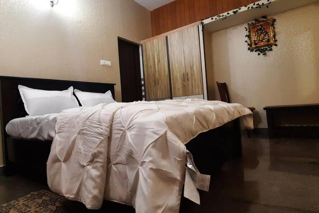 蒂鲁帕蒂Tejovrishananda Luxury Stays的卧室配有一张带白色棉被的大床