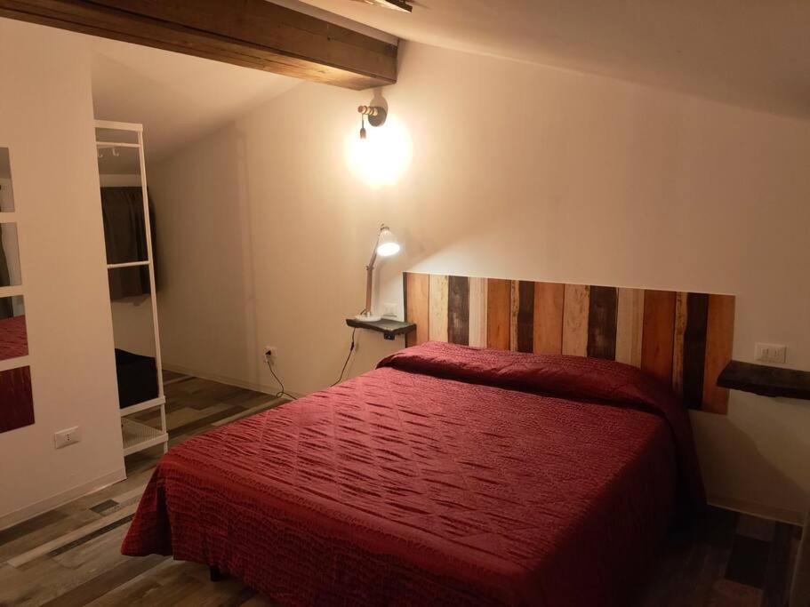 Villanovacasa vacanze Villanova - 4 posti letto的一间卧室配有红色的床和红色毯子