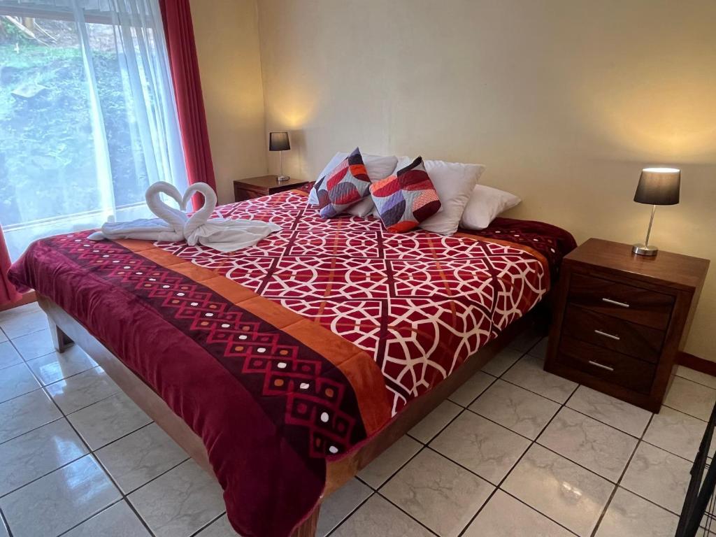 蒙泰韦尔德哥斯达黎加La Casa Bonita的一张带红色棉被的床,上面有弓