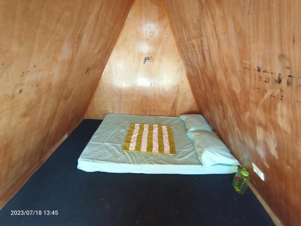 科代卡纳尔Croods Farm Stay - Kodaikanal的小房间,木墙里设有一张床