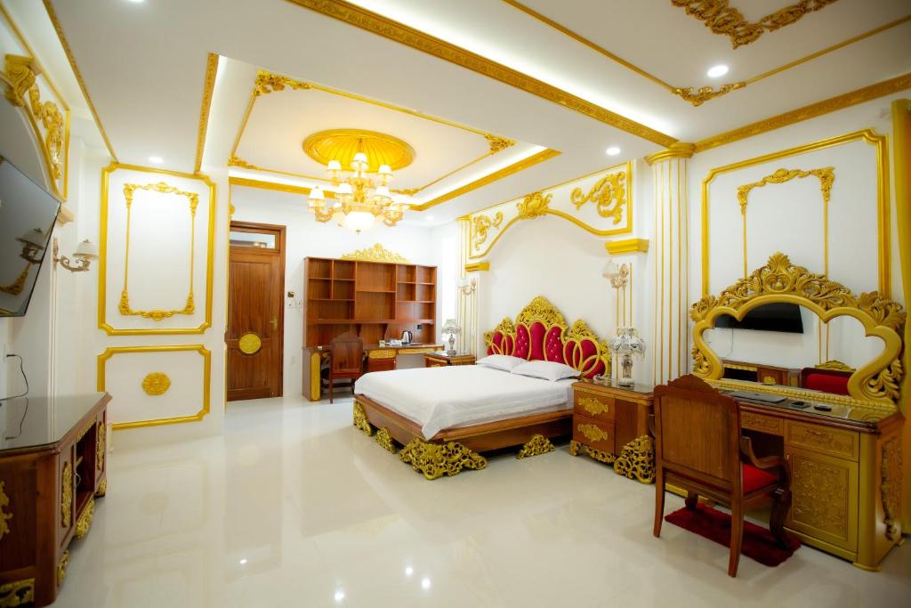 广义KING VILLA QUẢNG NGÃI的一间卧室配有一张特大号床和一张书桌