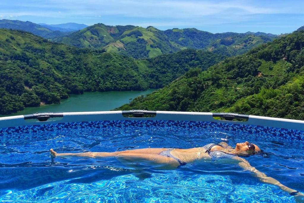 SamanáCasa Kakawa Ecolodge的一位女性躺在一座山地游泳池里