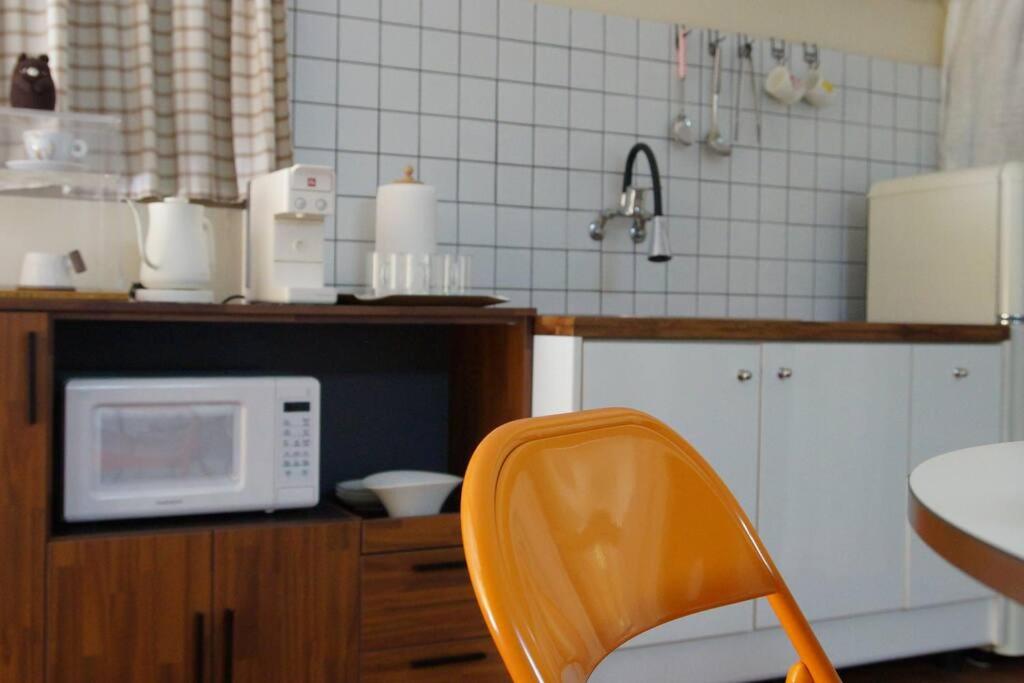 群山市Zibro的厨房配有橙色椅子和微波炉