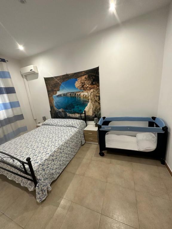 奇尼斯Casa Cinisi - Casa Vacanze的一间卧室设有两张床,墙上挂着一幅画