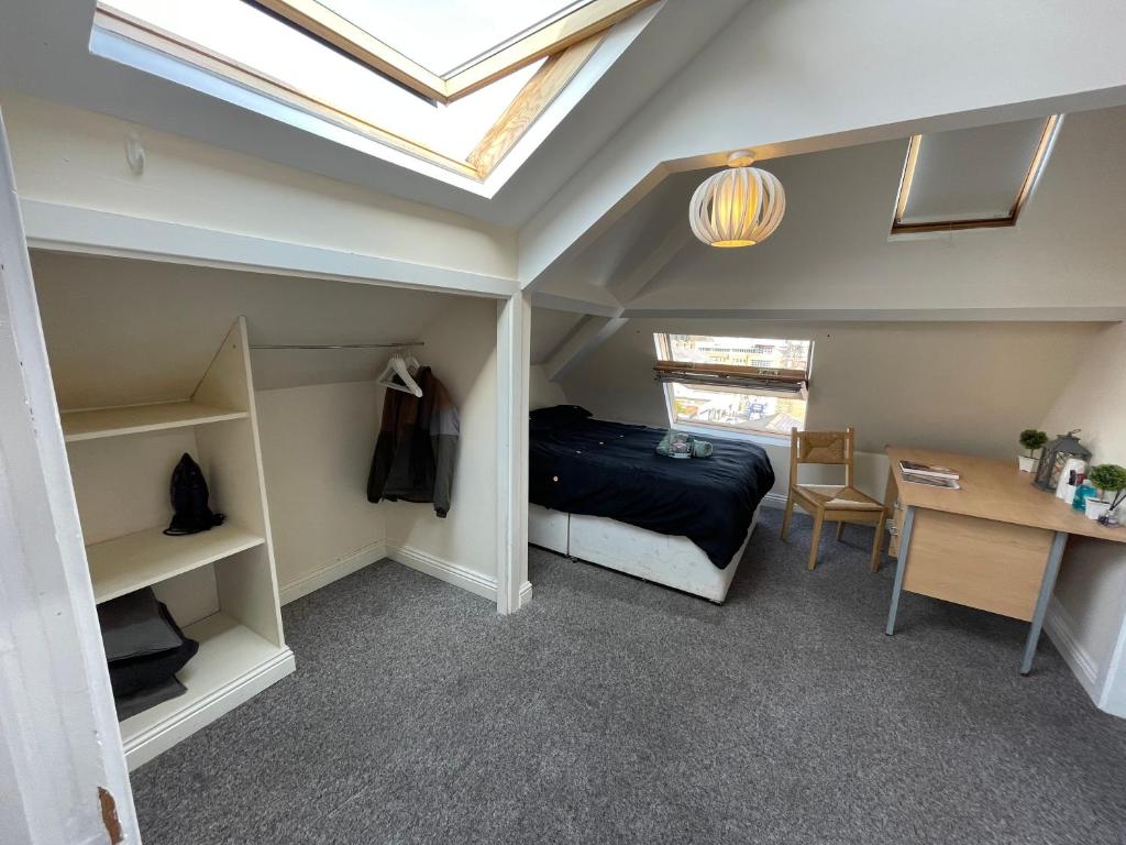 泰恩河畔纽卡斯尔Cosy Room in city centre的一间卧室配有一张床和一张书桌,天窗