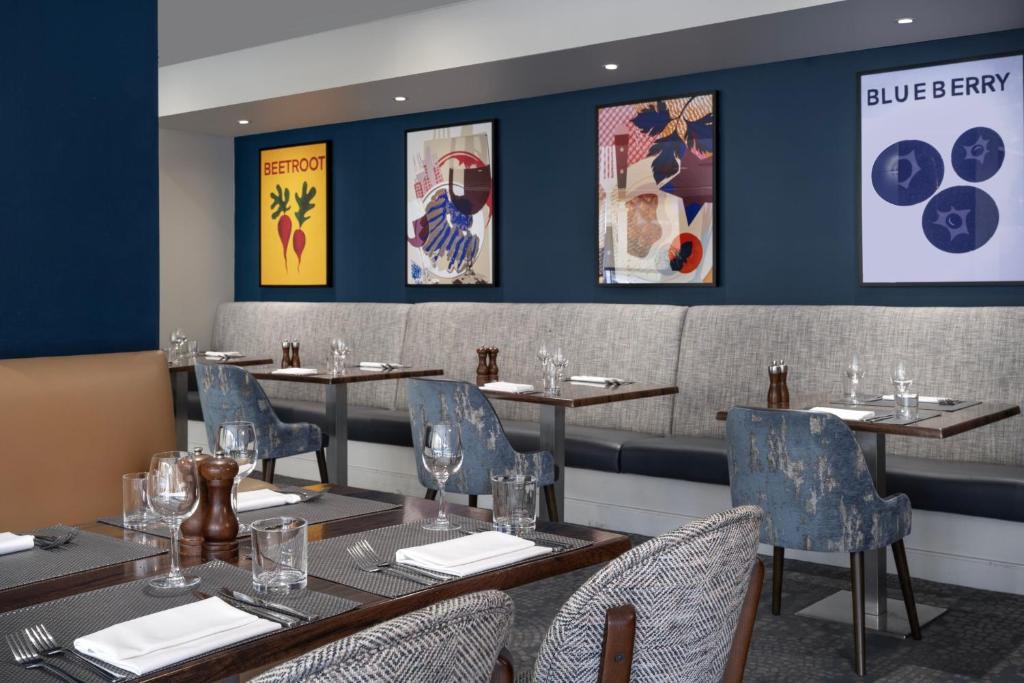 爱丁堡Delta Hotels by Marriott Edinburgh的餐厅内带桌椅的用餐室