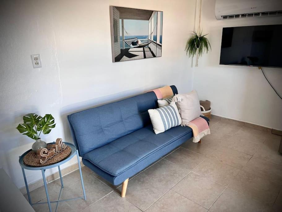 库莱布拉Rota- Casa Carmen Culebra的客厅配有一张蓝色的沙发,配有一张桌子