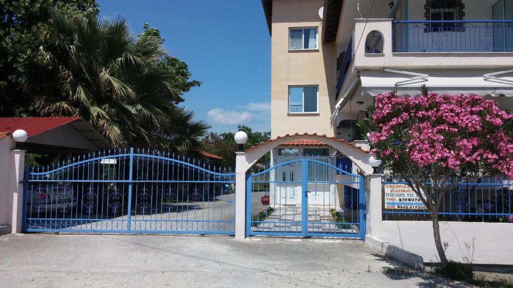 尼弗拉斯纳Tsolakis Apartments的一座花粉的建筑前方的蓝色门