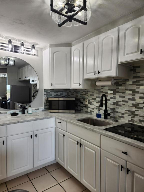 代托纳海滩Modern Beach Condo-Daytona Beach的白色的厨房配有白色橱柜和水槽